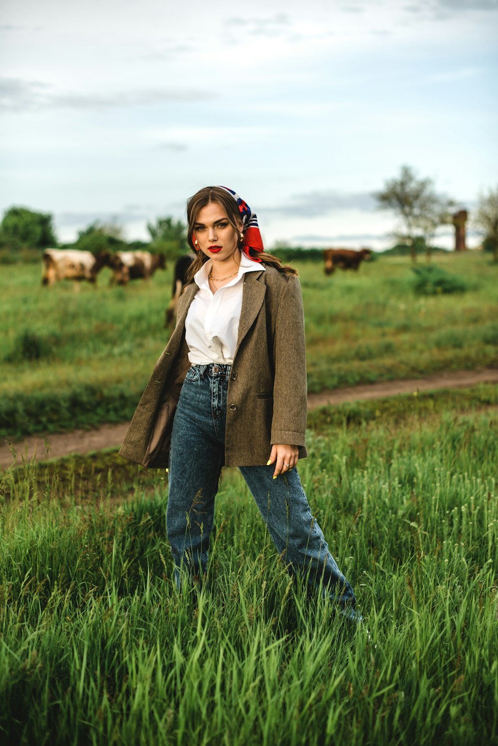 woman in brown coat standing on green grass field during daytime