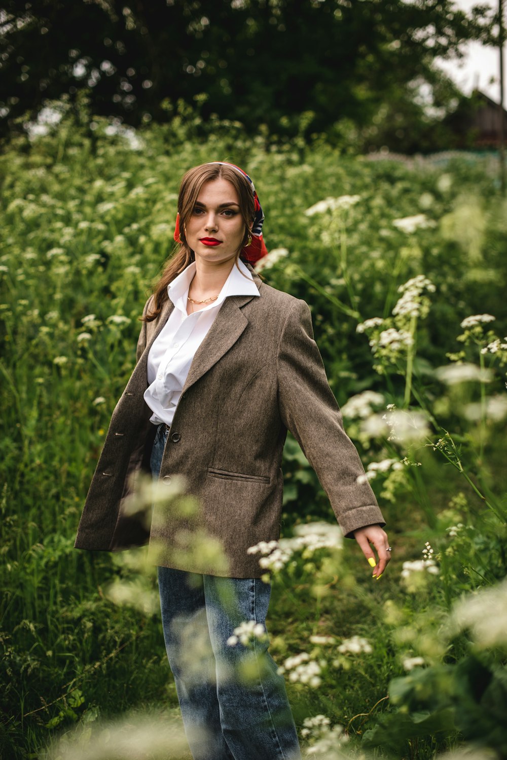 woman in gray blazer standing near green plants during daytime
