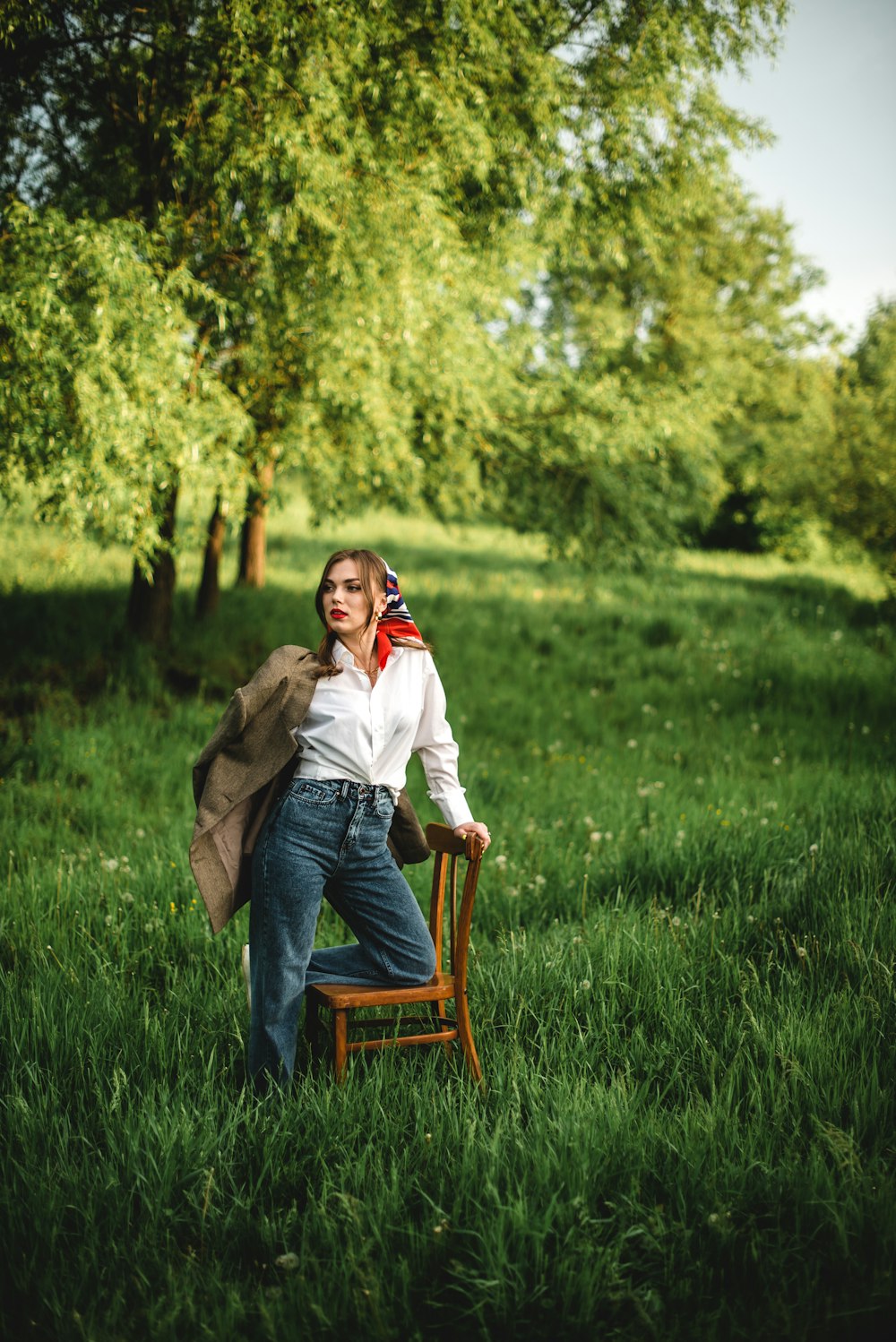 man and woman sitting on brown wooden chair on green grass field during daytime