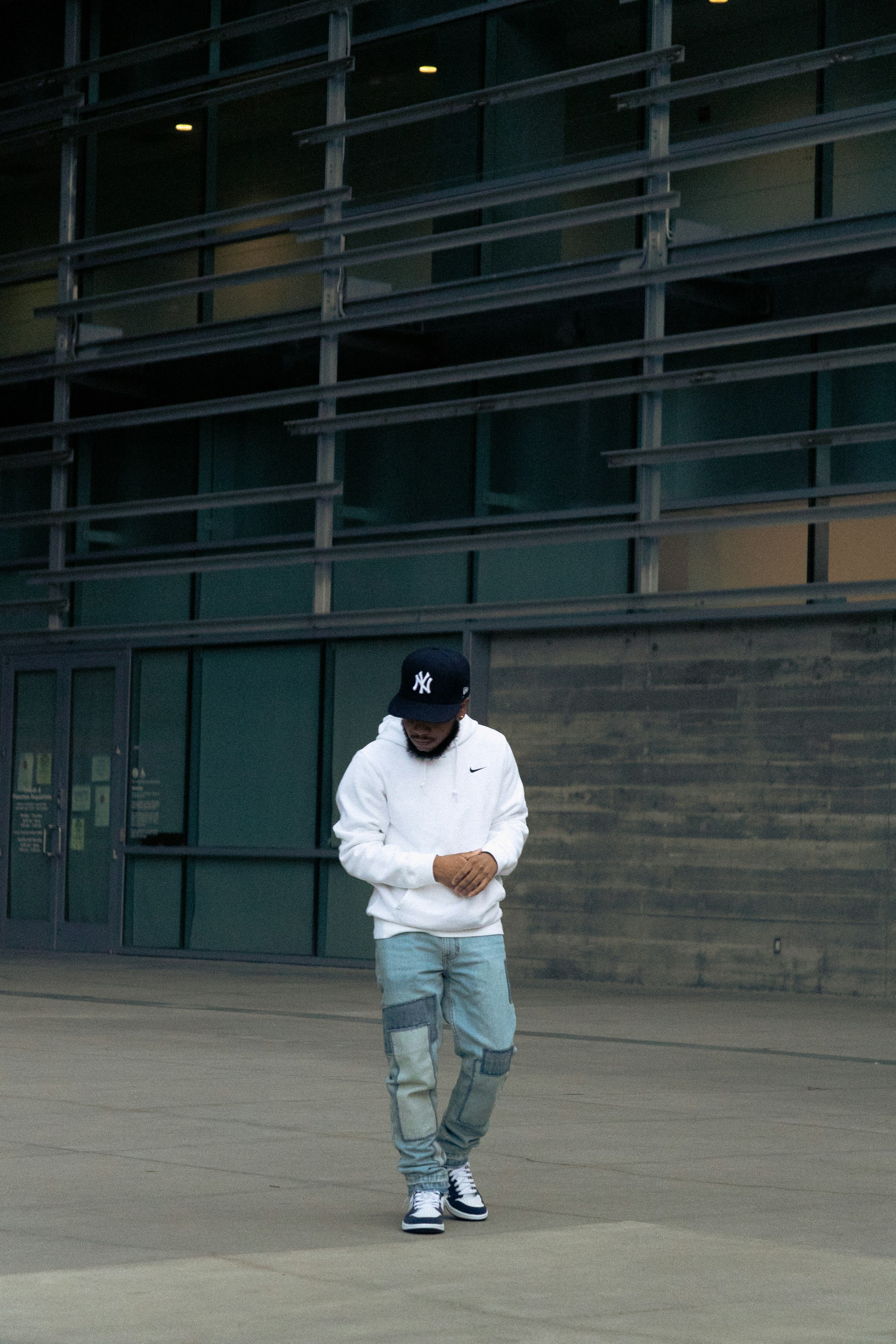 man in white long sleeve shirt and gray pants standing on gray concrete floor