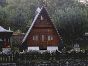 brown wooden house near green trees during daytime