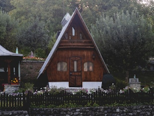 brown wooden house near green trees during daytime