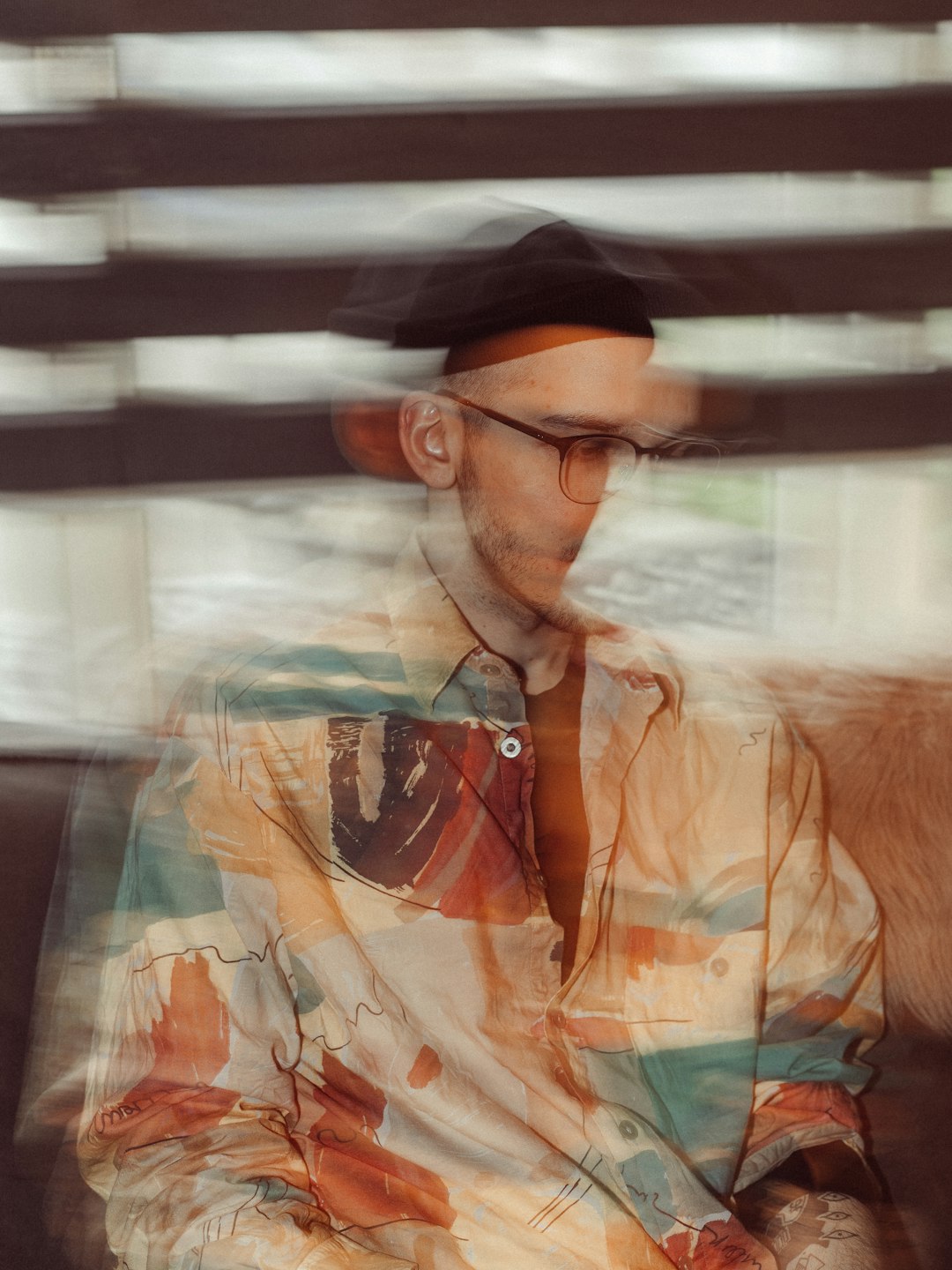 man in orange button up shirt wearing black cap