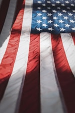 A close-up of a veteran's hand on a flag, symbolizing pride and honor.