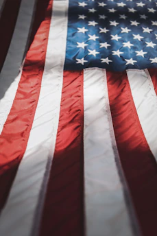 A close-up of a folded flag resting on a soldier’s uniform, symbolizing honor and sacrifice.