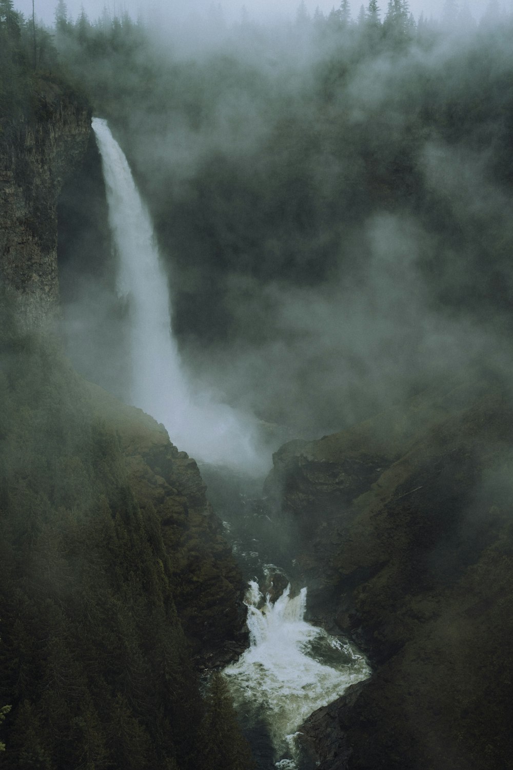 waterfalls in the middle of green mountain