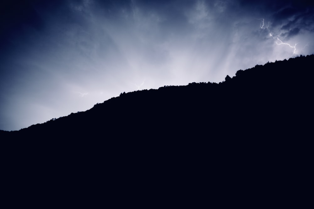 Silhouette des Berges unter blauem Himmel tagsüber