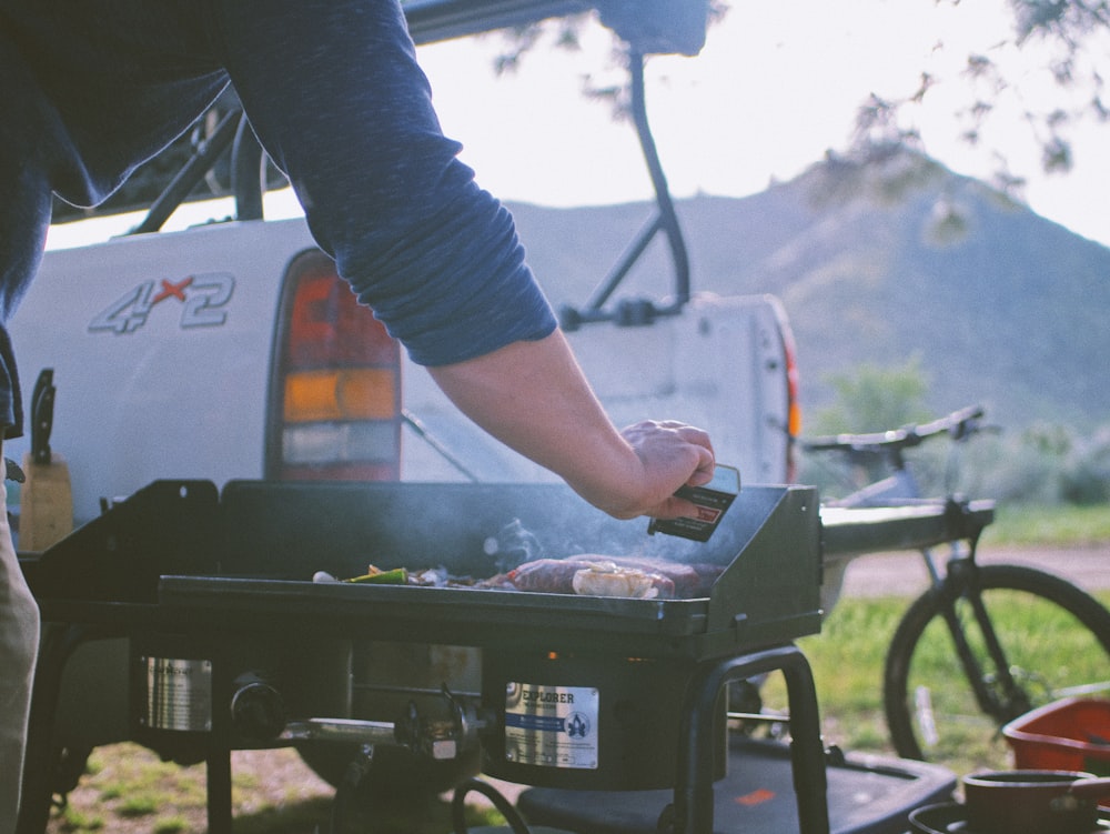 person in blue long sleeve shirt holding gray metal tray with food