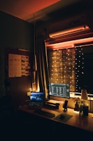 A cozy home office setup with soft lighting and a laptop open for an online listening session.