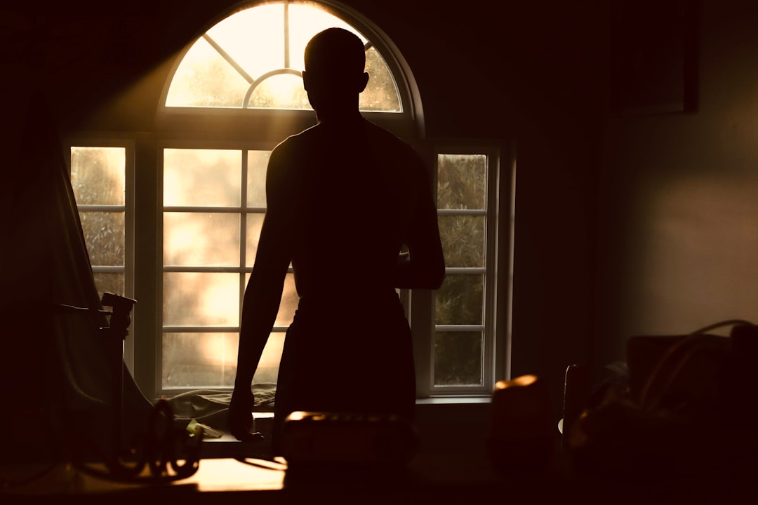 silhouette of woman standing near window