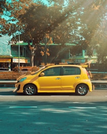 A cheerful passenger happily entering a bright yellow carpool vehicle on a sunny city street.