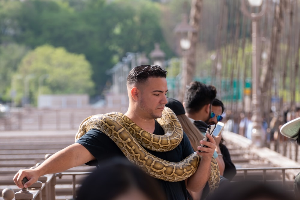 man in black crew neck t-shirt sitting beside woman in brown and black snake skin