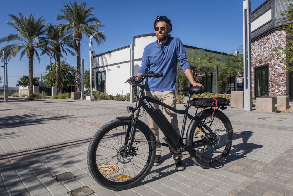 man in blue crew neck t-shirt riding black bicycle during daytime