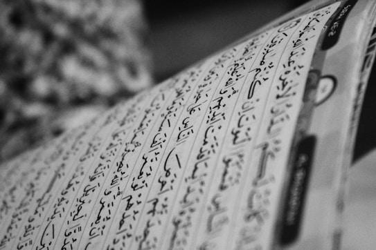 Black and white photo of a page with Arabic script, showing neatly written characters in rows with diacritical marks.