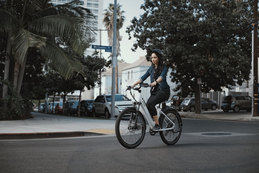 man in black jacket riding on bicycle during daytime