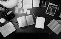 Close-up of educational materials and notes spread out on a wooden desk.