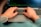 Close-up of hands typing on a laptop keyboard with a cup of coffee nearby.