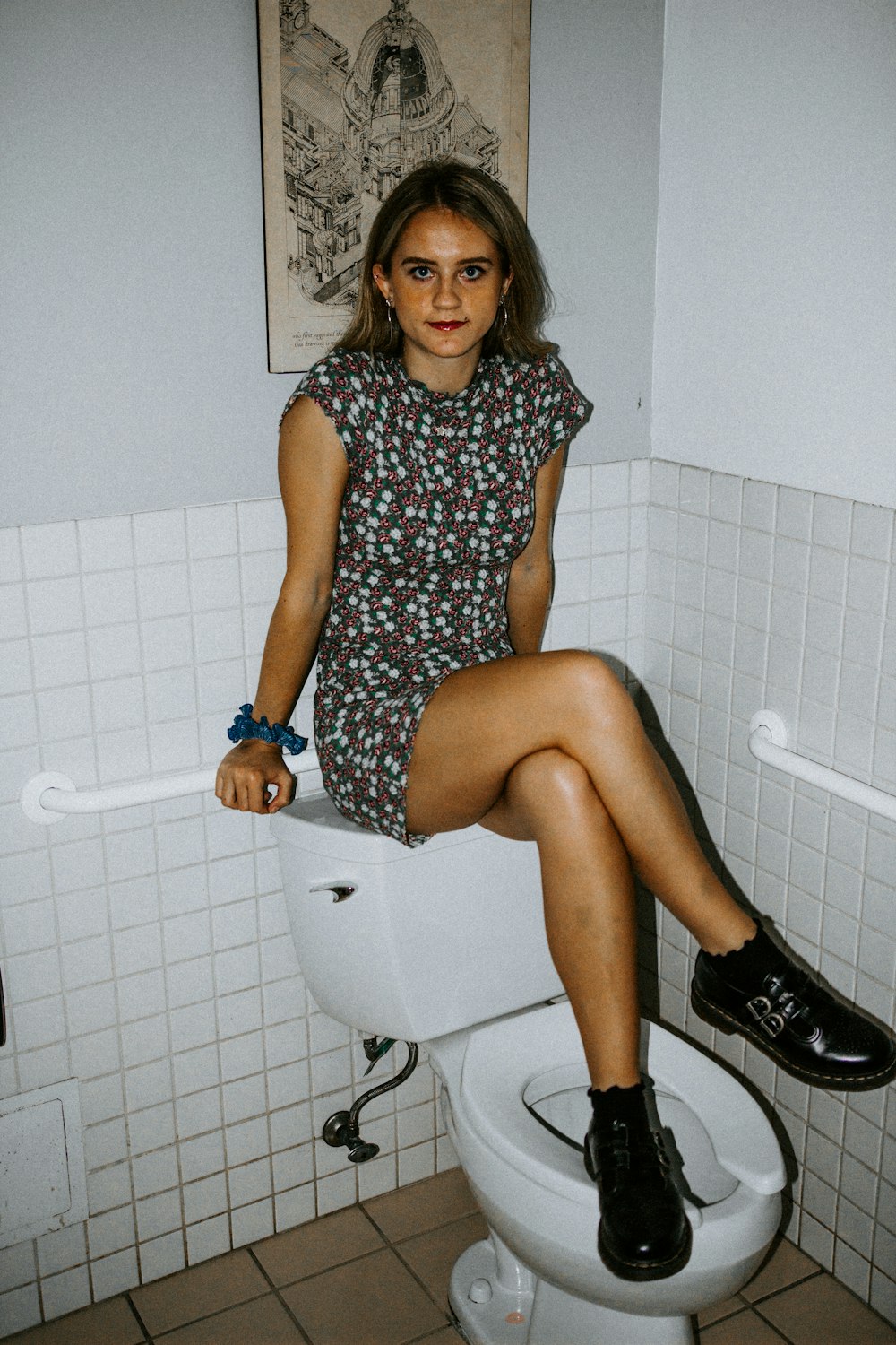 woman in blue and white polka dot dress sitting on white toilet bowl
