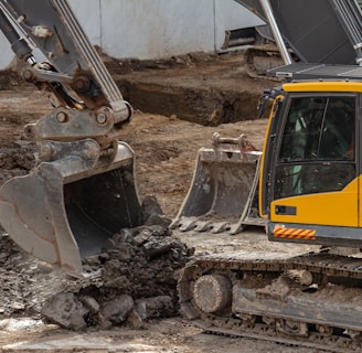 yellow and black excavator on brown soil