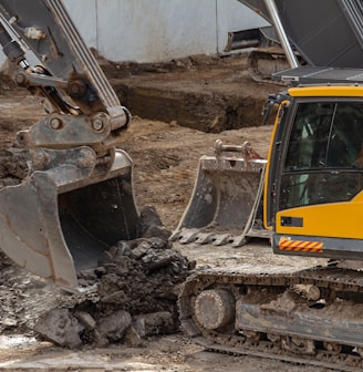 yellow and black excavator on brown soil