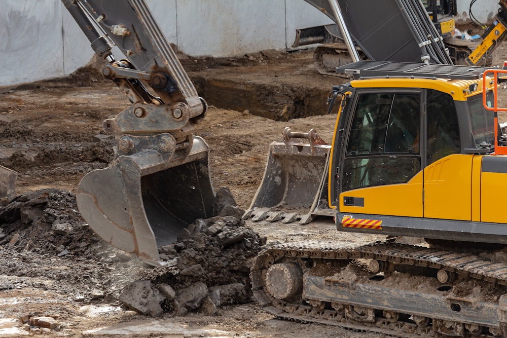 yellow and black excavator on brown soil