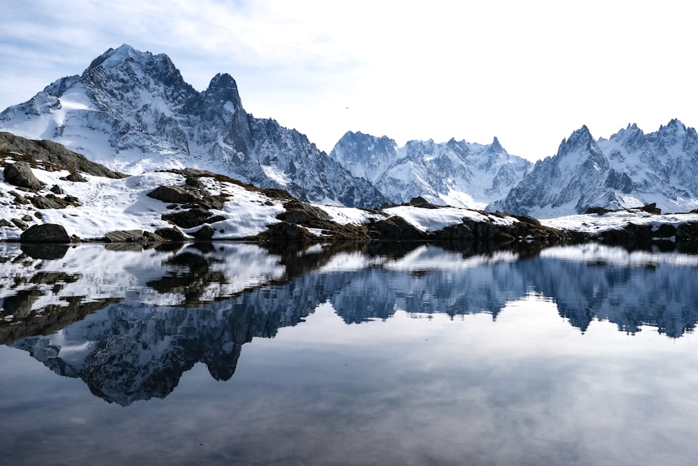 snow covered mountain near lake during daytime