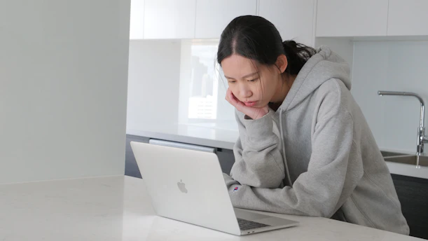 man in gray hoodie sitting beside white table
