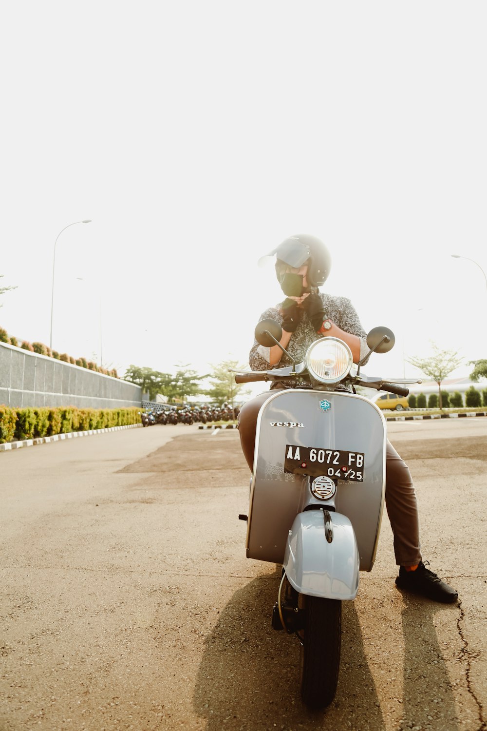 white motor scooter parked on gray concrete road during daytime