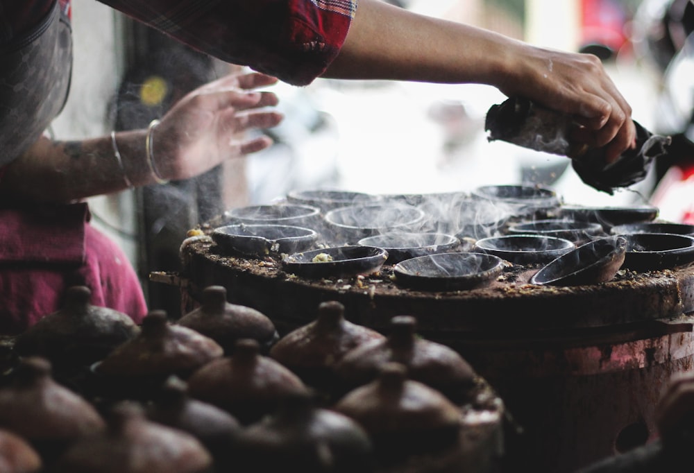 person holding black round fruit