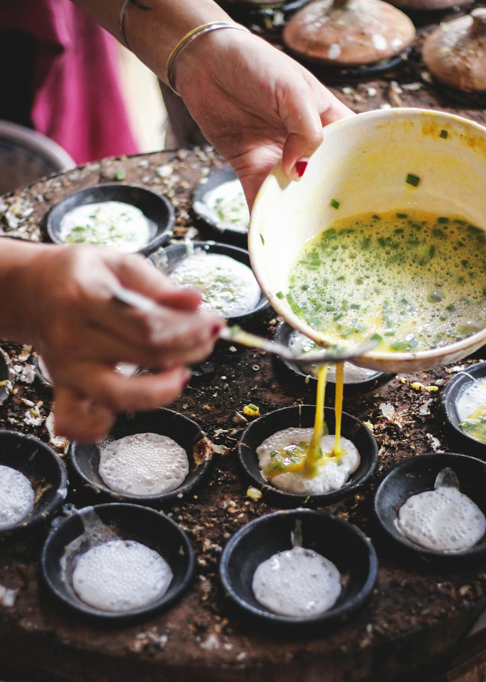 person pouring yellow liquid on white ceramic mug