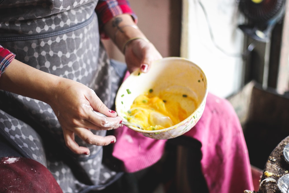 person holding white ceramic bowl