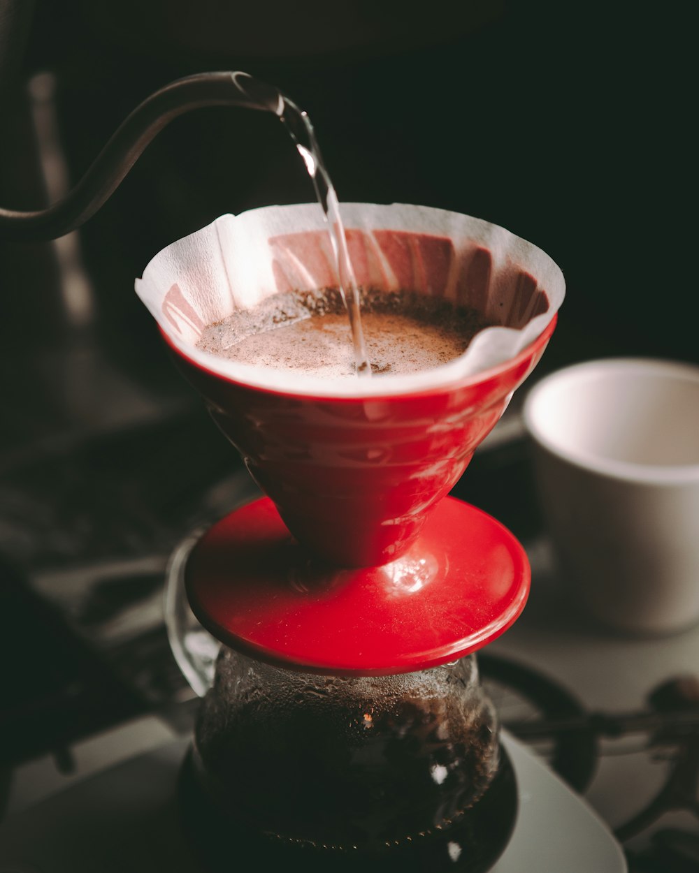 red and white ceramic cup with brown liquid