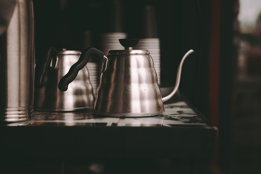 stainless steel teapot on table