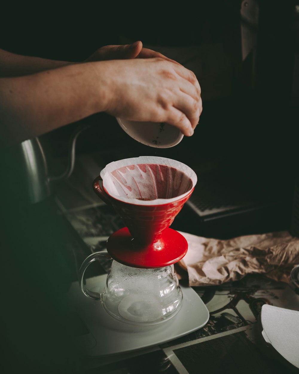 person holding clear glass cup with red liquid