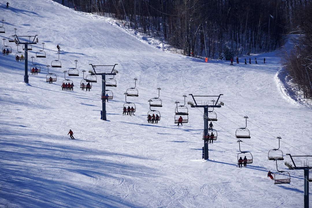 people riding ski lift on snow covered ground during daytime