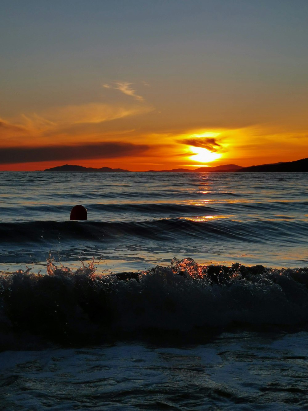 Meereswellen stürzen während des Sonnenuntergangs an Land