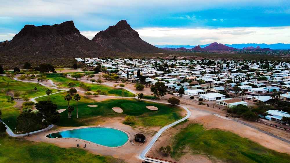 aerial view of green grass field near lake and mountain during daytime