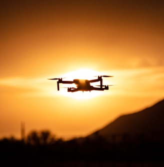 white drone flying during sunset