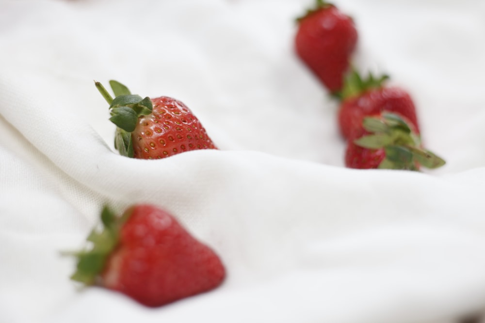 red strawberries on white textile