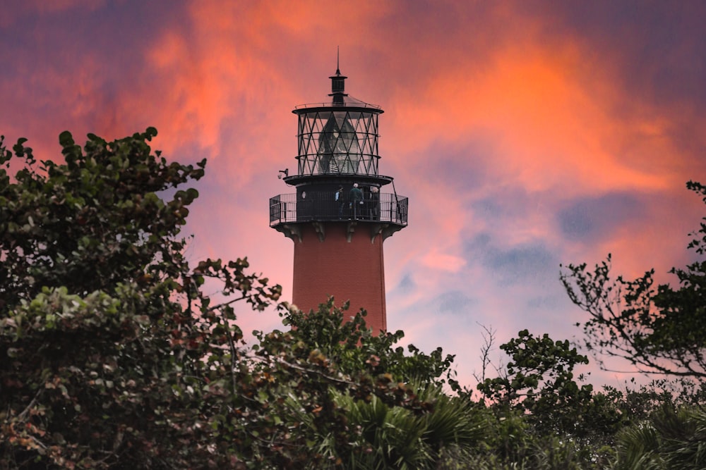 brown and white lighthouse under orange and blue sky