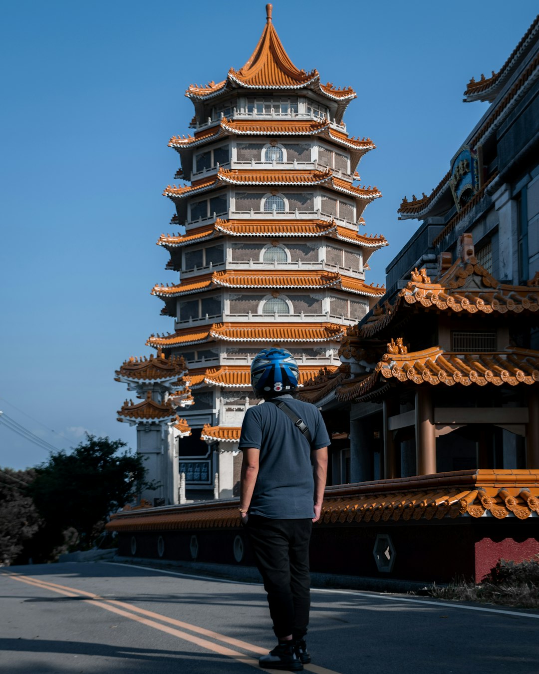 man in black jacket standing near brown and white temple during daytime
