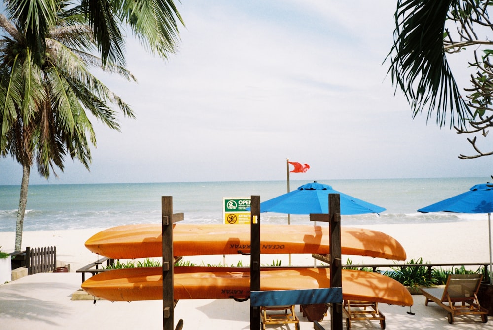 brown wooden lounge chairs on beach during daytime