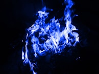 A serene blue flame burning steadily surrounded by ethereal mist.