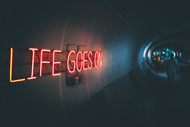 a neon sign that reads life goes on