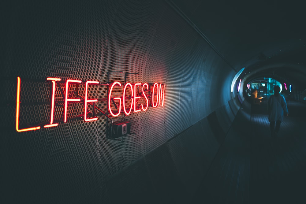 a neon sign that reads life goes on