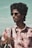 man in pink and white floral button up shirt wearing black sunglasses