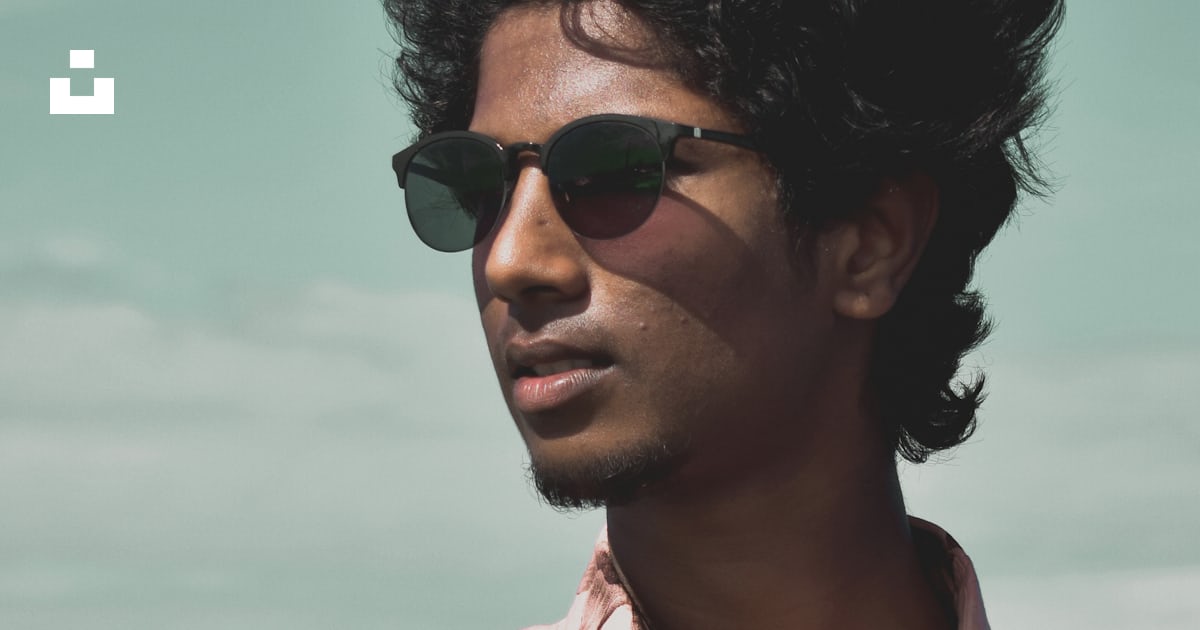 Man in pink and white floral button up shirt wearing black sunglasses ...