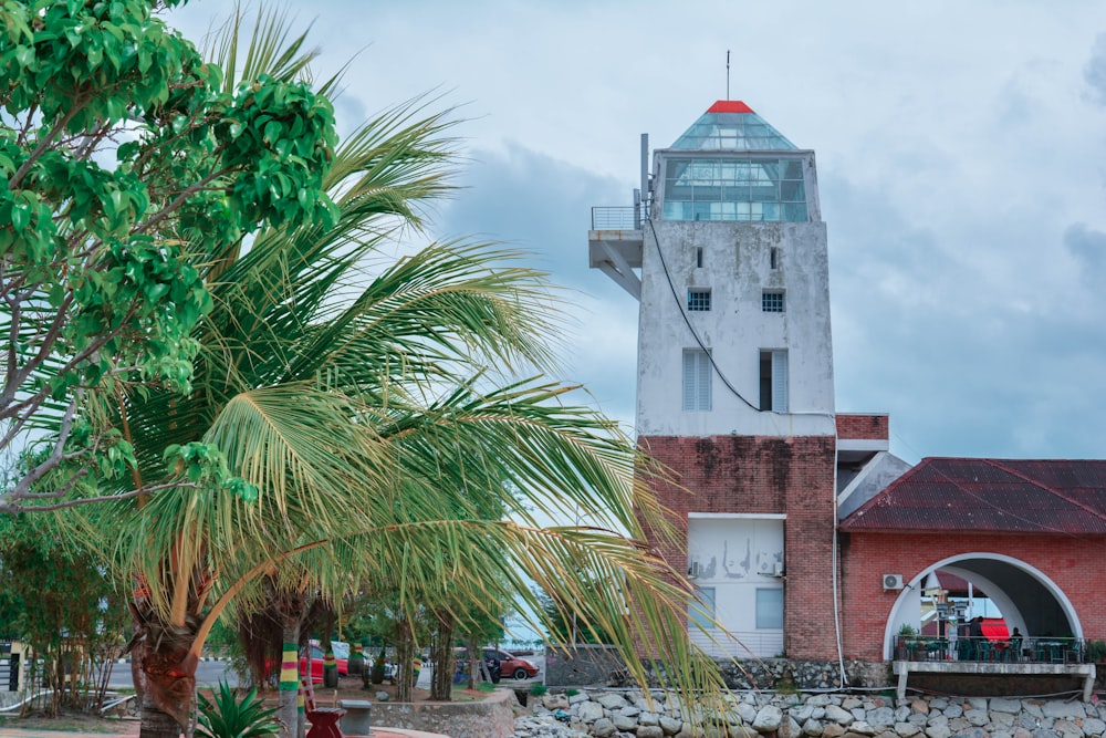 white and brown concrete building near palm tree under white clouds during daytime