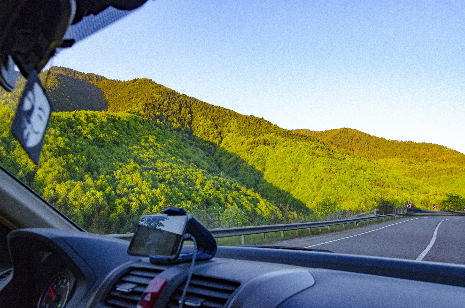 A scenic view of a taxi driving through a picturesque landscape, representing outstation travel.