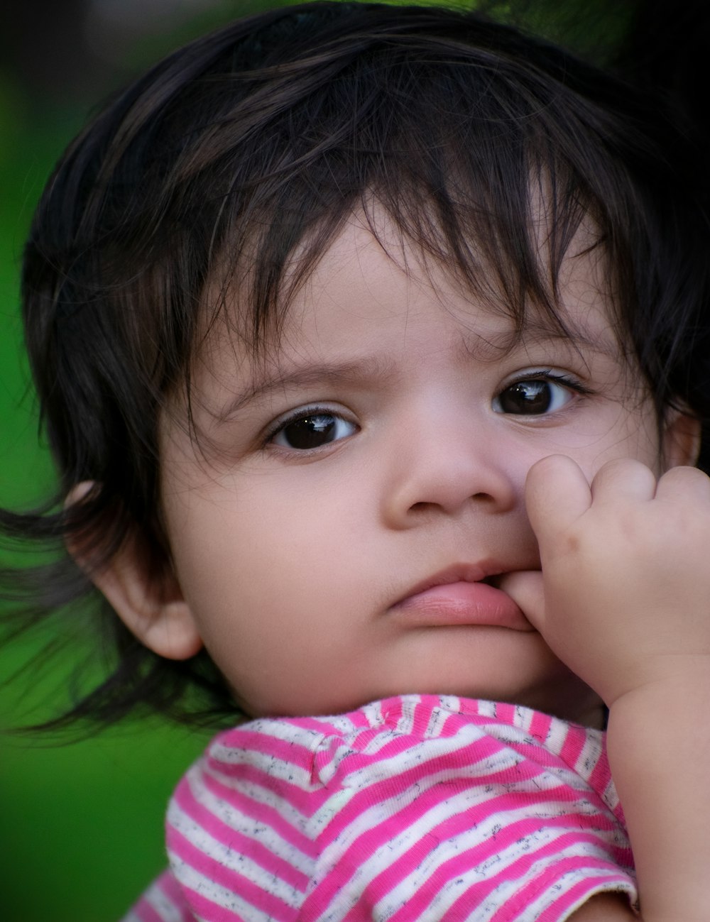 girl in green shirt covering her eyes with her hand